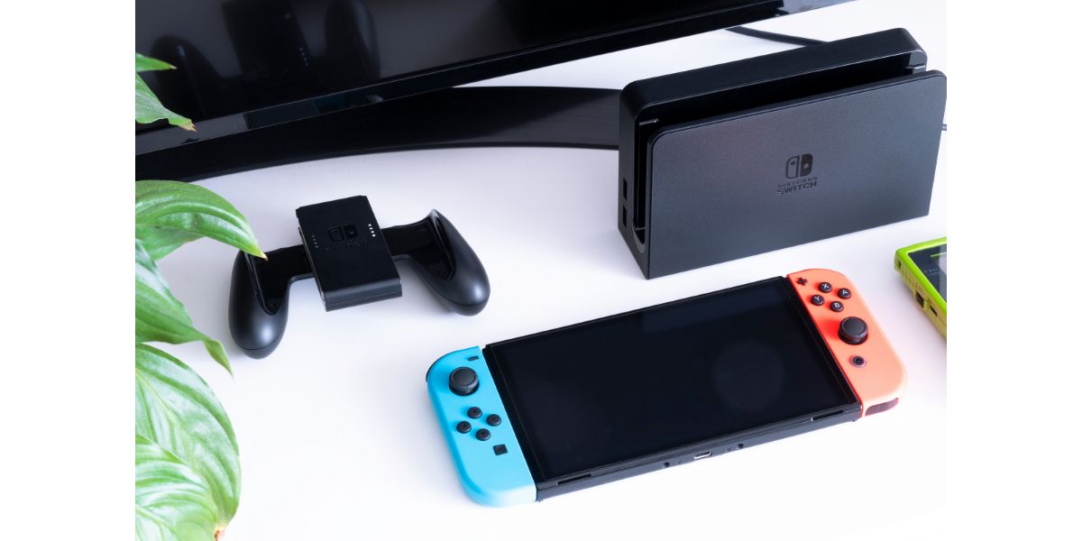 AdobeStock_544600298_Editorial_Use_Only Nintendo Switch video game console with dock in a home living room on TV stand infront of TV No people.