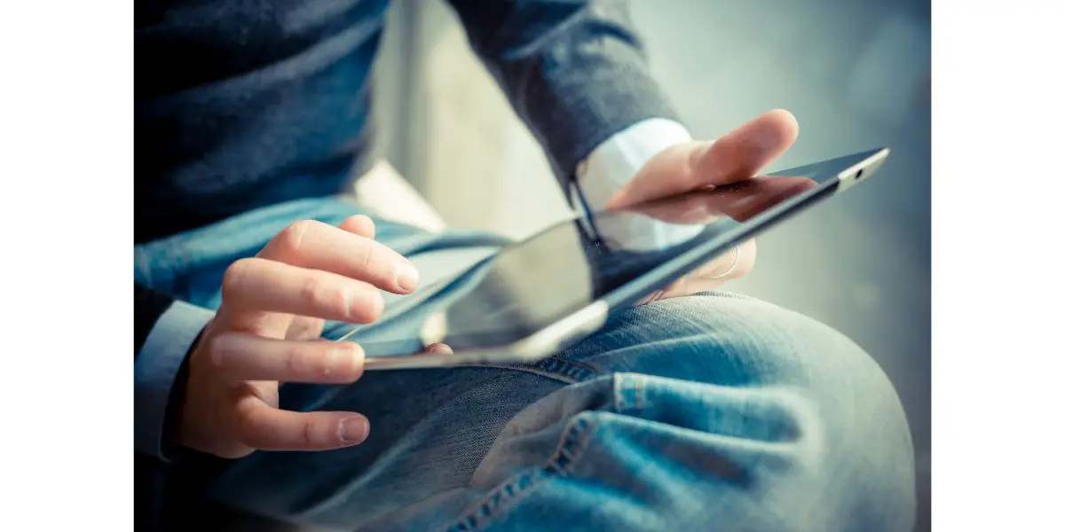 AdobeStock_60663020 close up hands multitasking man using tablet, laptop and cellhpo