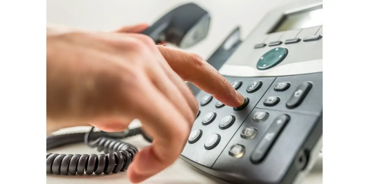 AdobeStock_66411287 Making a phone call on office corded phone