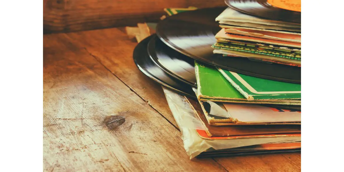 AdobeStock_93743837 records stack with record on top over wooden table. vintage