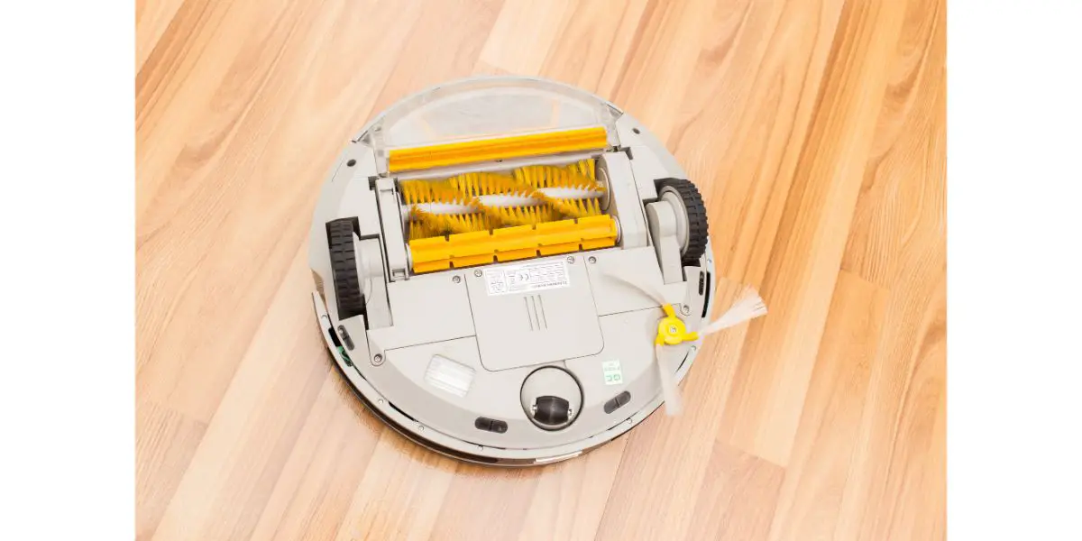 Depositphotos_100620086_L Flipped bottom of white robotic vacuum cleaner on wood background showing brushes, camera sensor, wheels