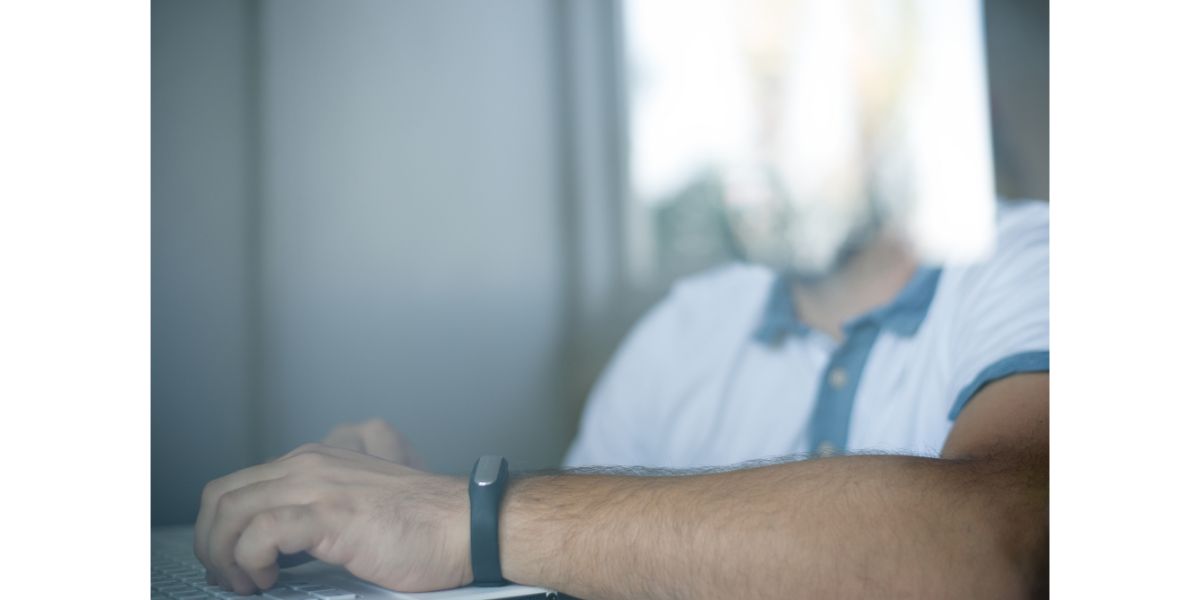 Depositphotos_123374402_L Man with fitness tracker in the office through glass window