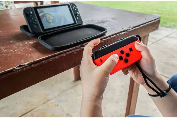 Depositphotos_177993680_S Editorial of close up kid hold joystick playing the nintendo switch outside