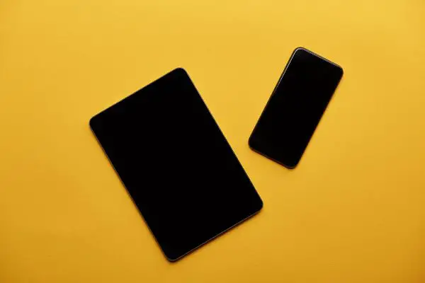 Depositphotos_223901218_S Top view of tablet and smartphone on yellow surface