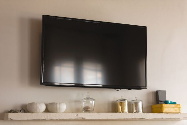 Depositphotos_241559524_S Modern LED television fixed on the wall above bowl and box at home