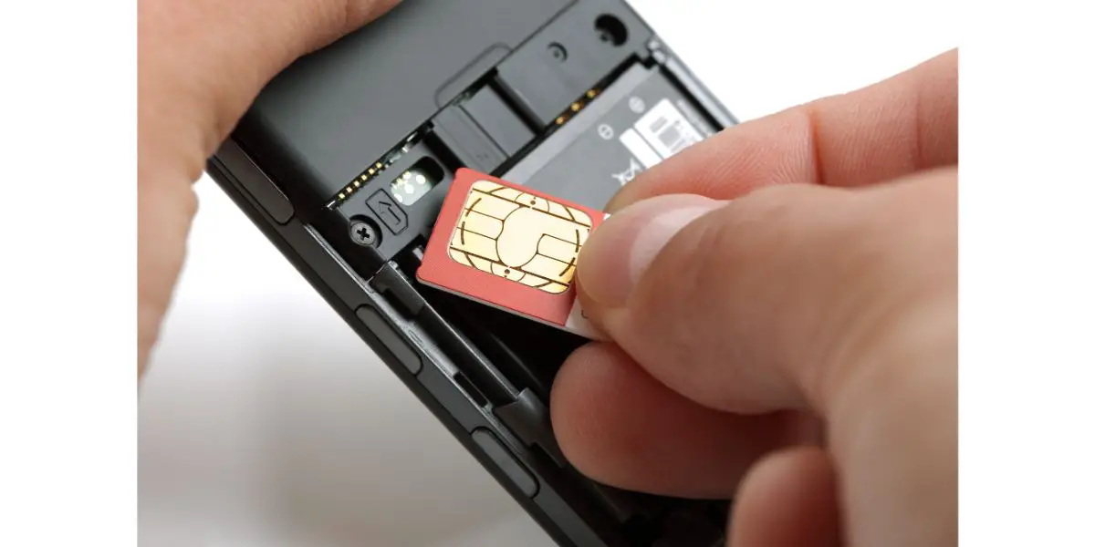 Depositphotos_24510939_L Inserting a redish sim card into the back of a black phone. White background