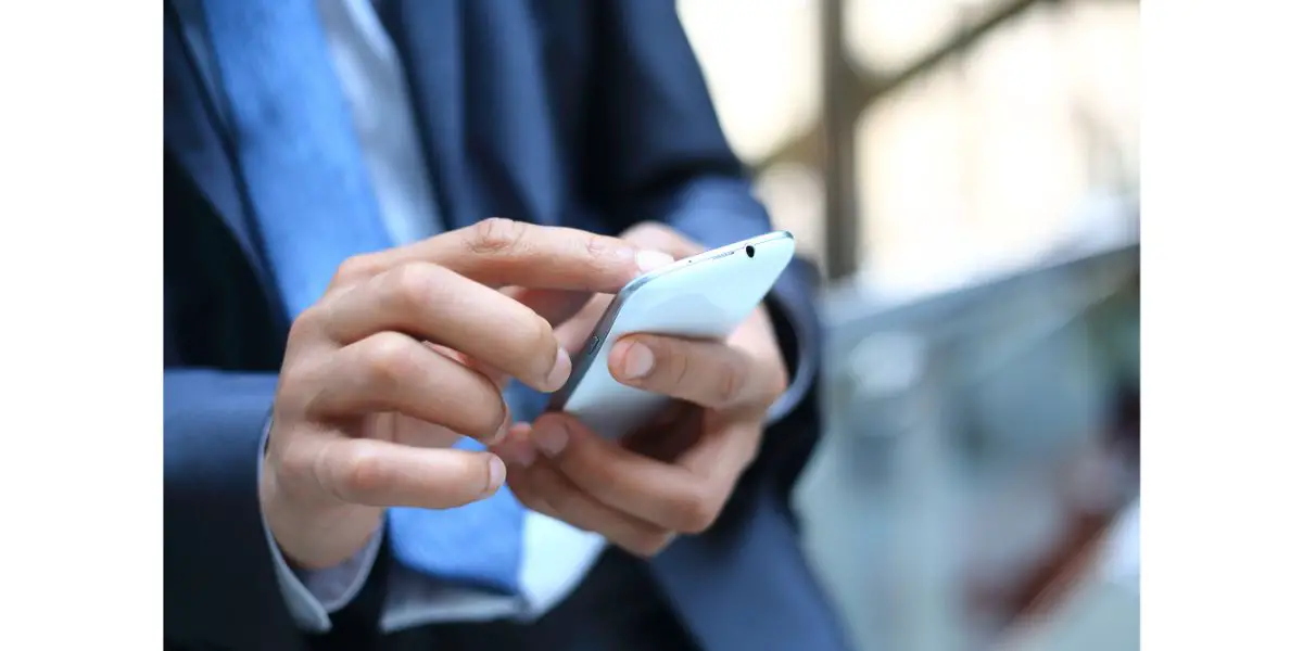 Depositphotos_24587177_L Business man in suit using mobile smart phone. Blurred background