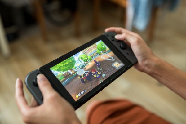 Depositphotos_258086678_S Woman playing Nintendo Switch at home