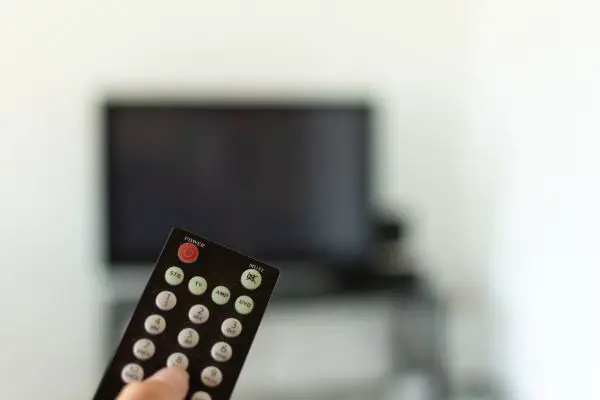 Depositphotos_274780456_S Watching TV, remote focused with tv blurred