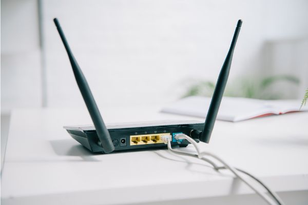 Depositphotos_310724218_S Black plugged router on office table in sunshine