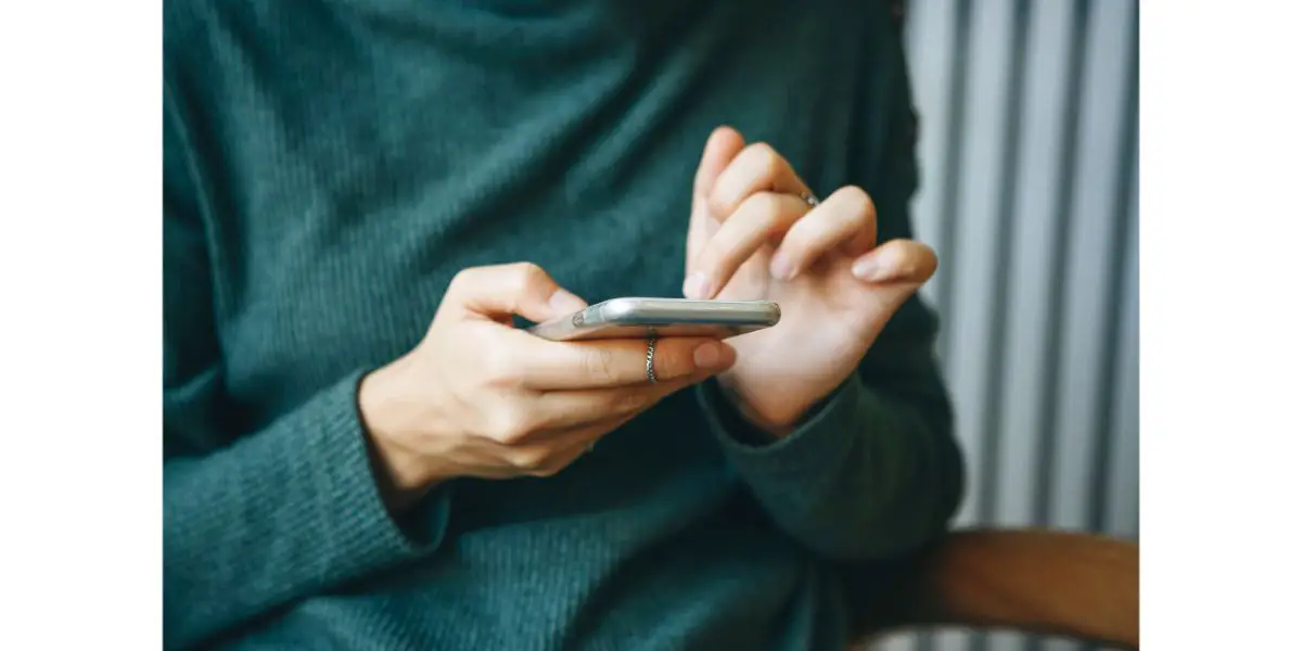 Depositphotos_329123518_L girl wearing a dark green sweater on her phone