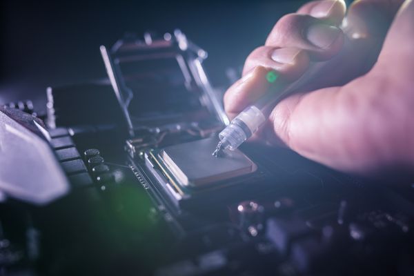 Depositphotos_332703172_S Close up to technician squeezing or application of thermal paste