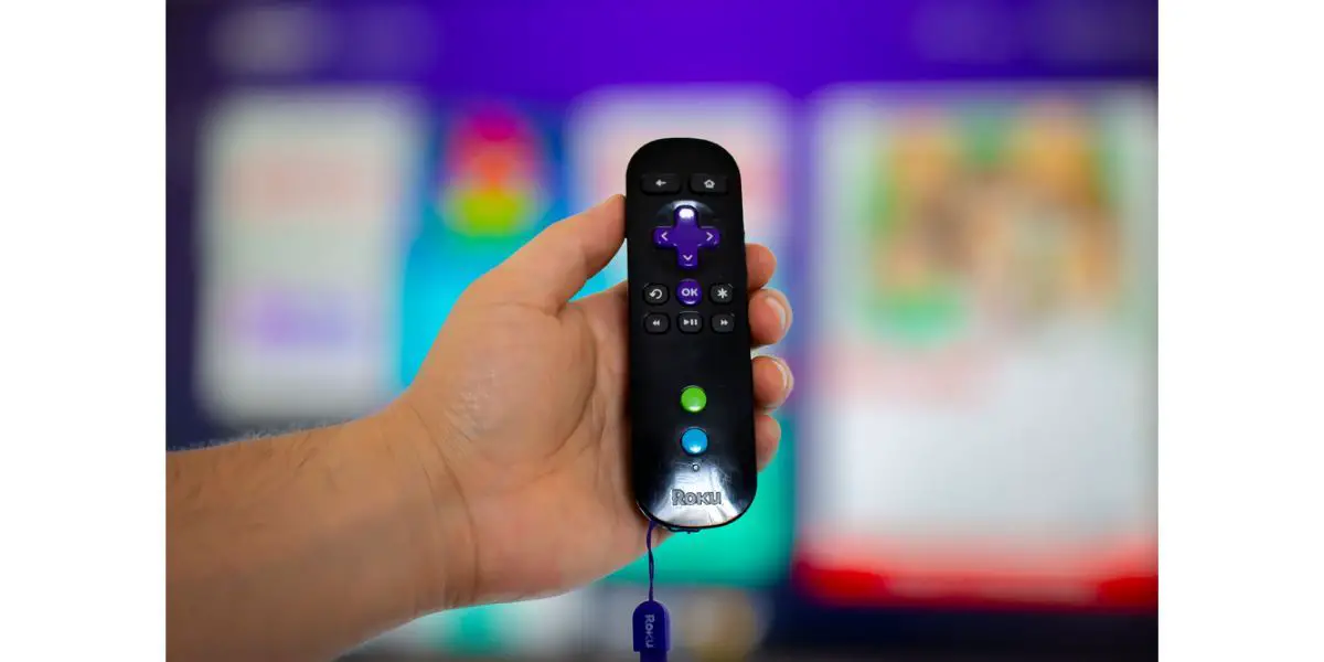 Depositphotos_370141678_S A person holding a Roku remote control with a screen tv on the background