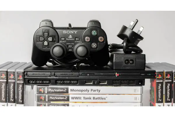 Depositphotos_370476080_S An original slim black sony playstation 2 console with games and controls