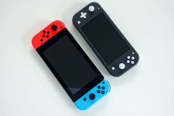 Depositphotos_377434238_S A multiplayer Nintendo Switch and single player Nintendo Switch Lite gaming consoles side by side.