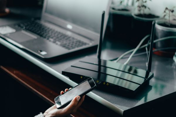 Depositphotos_389316096_S Wireless router and a young person using mobile phone