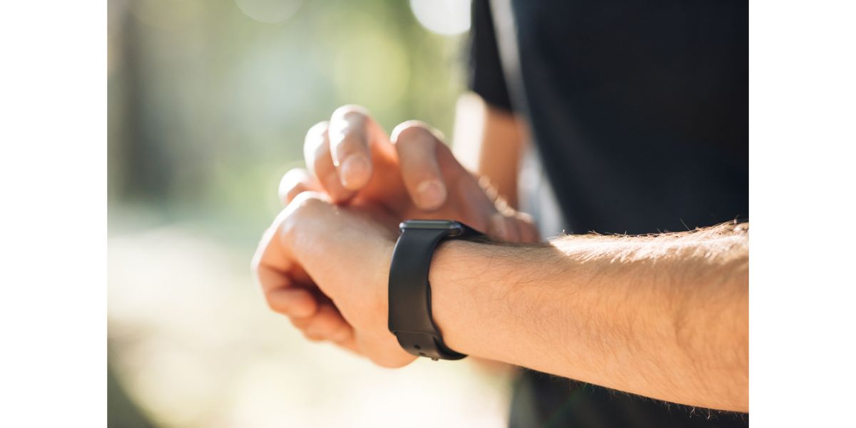 Depositphotos_416009186_S man checking his smartwatch outdoors. Blurred background