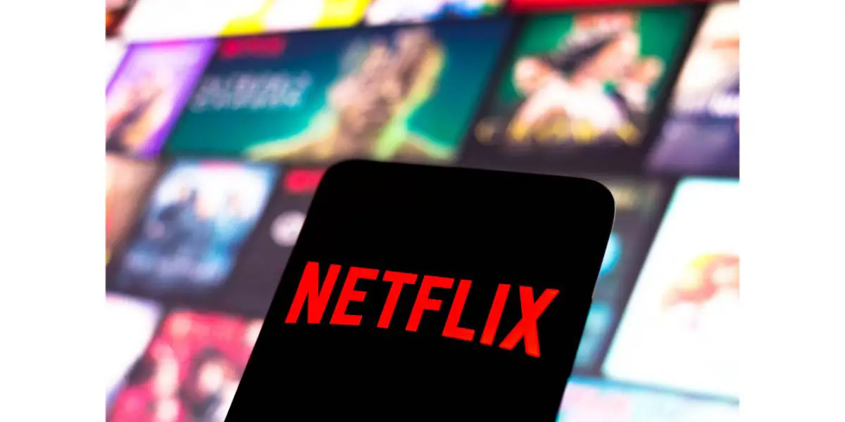 Depositphotos_545712008_L In this photo illustration, the Netflix logo is displayed on a smartphone screen with netflix shows in the background