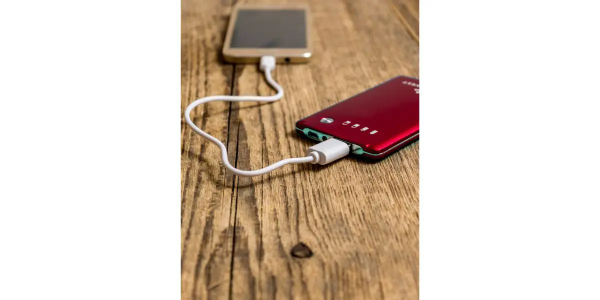 Depositphotos_98552950_L Mobile phone charging on wood background