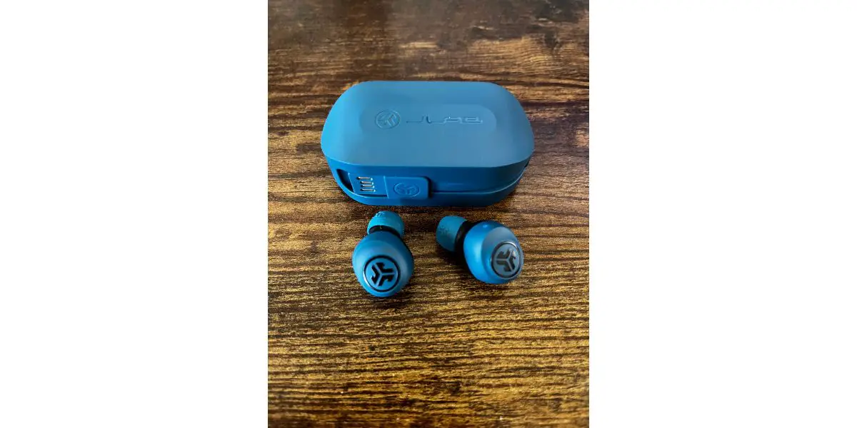 Light Blue Jlab Go air case with light blue earbuds nearby taken on wood background