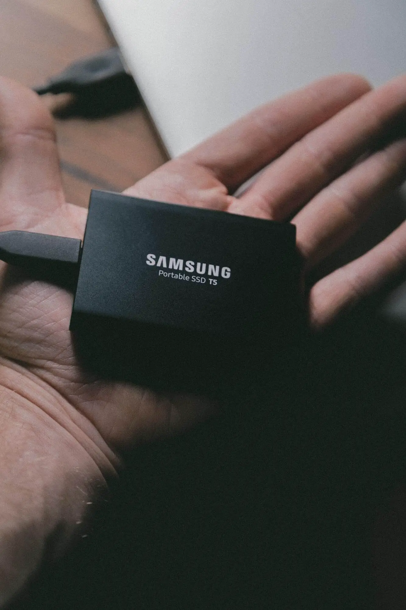 An external SSD is the palm of someone's hand